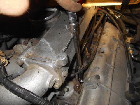1992 Ford Bronco - Close-up of engine work, showing a hand operating a wrench on internal engine parts.