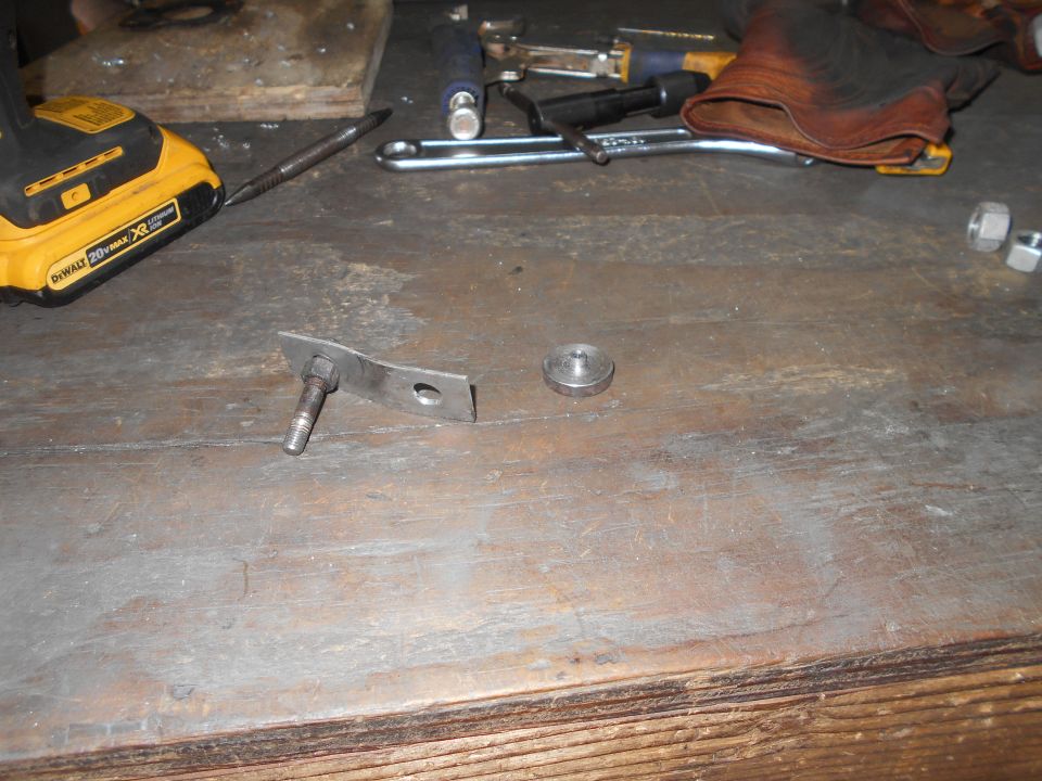 Workbench with a DeWalt drill, screwdriver, wrench, leather glove, bolt, washer, and nuts