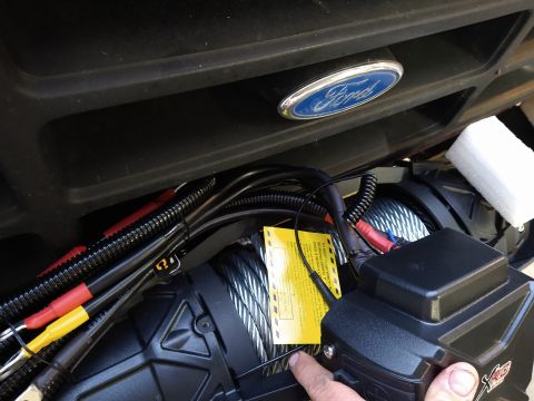 1996 Ford Bronco - A close-up view of a winch installed on a vehicle, with a Ford emblem visible above.