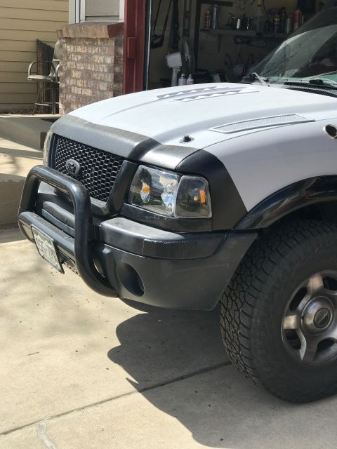 2000 Ford Explorer - The front grille and headlights of a white pickup truck are visible.
