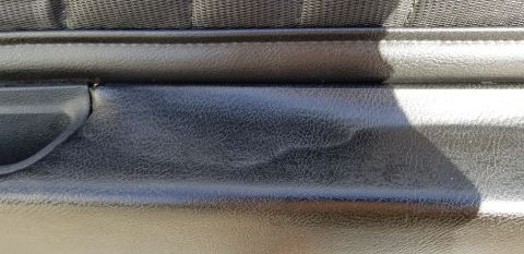 1973 Chevrolet Camaro - Close-up view of a black interior door panel, showing the textured vinyl and fabric trim details.