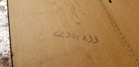 1973 Chevrolet Camaro - A close-up view of handwritten numbers on a textured brown surface.