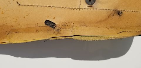 1973 Chevrolet Camaro - Close-up of aged car seat fabric shows damage and a vent hole.