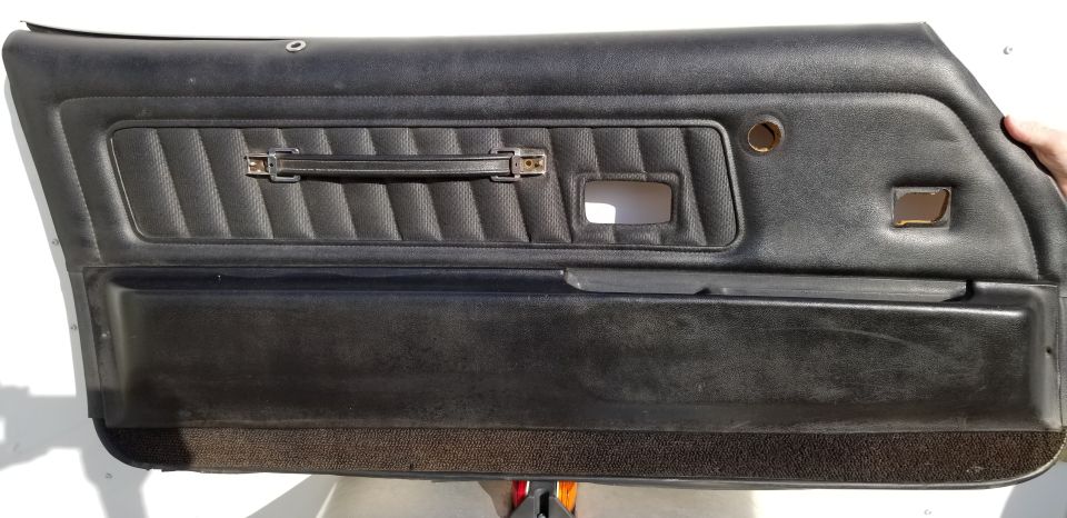 Black car door panel with ribbed insert and pull handle