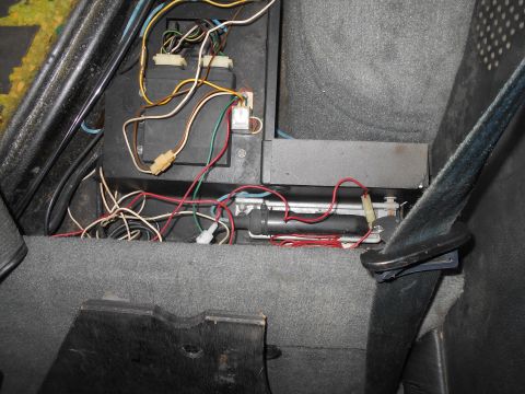 1992 Ford Bronco - Close-up view of the complex wiring harness and electronic components located beneath the vehicle's seat.
