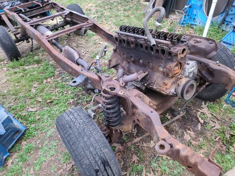1995 Ford F-150 - The chassis and engine of a 1995 Ford F-150 are shown, heavily rusted and in a state of disassembly.
