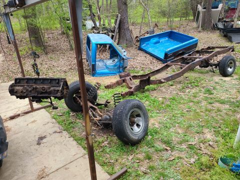1995 Ford F-150 - Truck chassis, engine, cab, and bed disassembled and laid out in a yard.