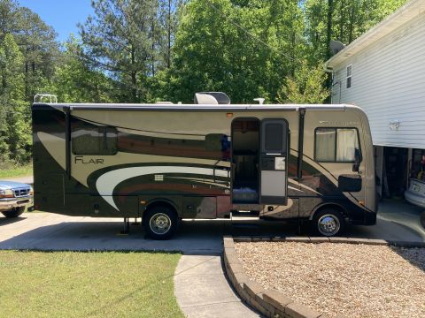 2015 Ford F-550 - A Fleetwood RV with the model name 'Flair' is parked on a driveway next to a residential building.