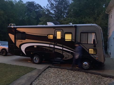 2015 Ford F-550 - A motorhome is parked in a driveway next to a silver SUV.