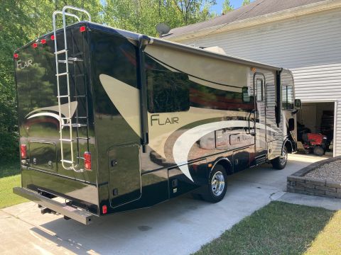 2015 Ford F-550 - This RV motorhome features a two-tone paint scheme with 'Flair' badging and a rear ladder for roof access.