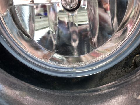 2015 Ford F-550 - A close-up view of a vehicle's headlight assembly, revealing etched text on the lens.