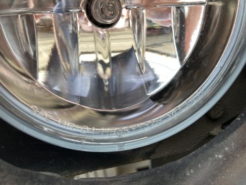 2015 Ford F-550 - Close-up of a vehicle headlight lens showing etched text and internal components.