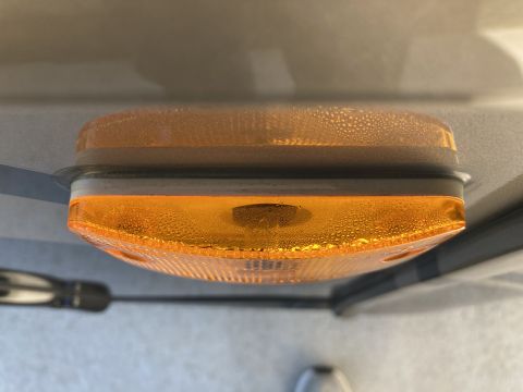 2015 Ford F-550 - Close-up of an amber marker light showing condensation, with a screwdriver visible to the left.