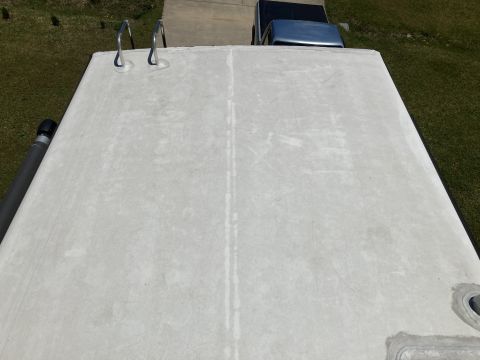2015 Ford F-550 - The roof of an RV is visible, with a blue pickup truck in the background.