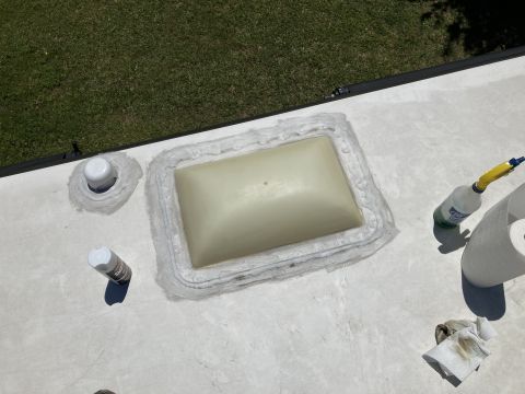 2015 Ford F-550 - RV roof repair in progress with sealant around a skylight and cleaning supplies.