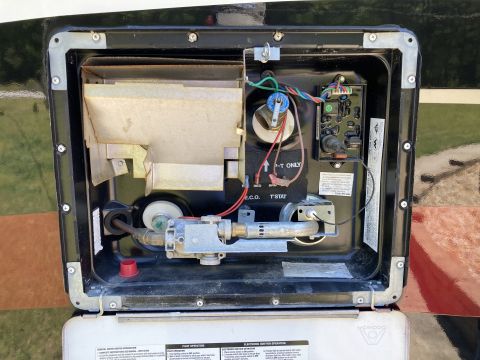 2015 Ford F-550 - Close-up view of the internal components of an RV water heater, showing the burner assembly and control module.