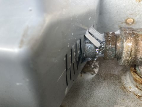 2015 Ford F-550 - A close-up view shows a leaking fitting on a propane tank, with visible corrosion and water droplets.