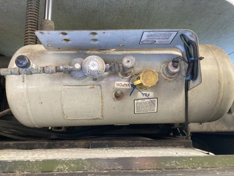 2015 Ford F-550 - A propane tank assembly with various fittings and labels is mounted on a vehicle.