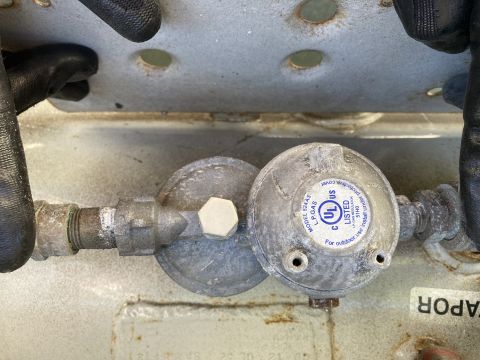 2015 Ford F-550 - Close-up view of a propane tank regulator, identified as model 524AS, with UL certification for outdoor use.
