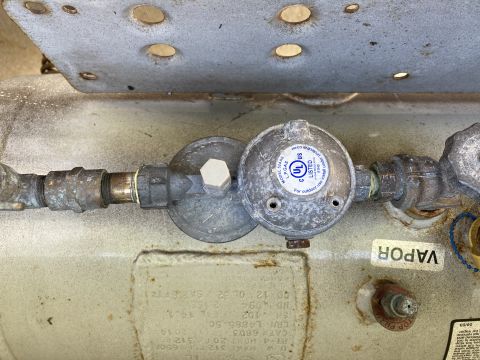 2015 Ford F-550 - Close-up of a propane tank regulator assembly, showing a UL listing and a vapor label. The tank itself has a visible date of 2014.