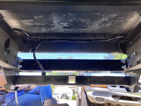2015 Ford F-550 - Underbody view of a truck, with visible wiring and a trailer hitch receiver. Another vehicle is in the background.