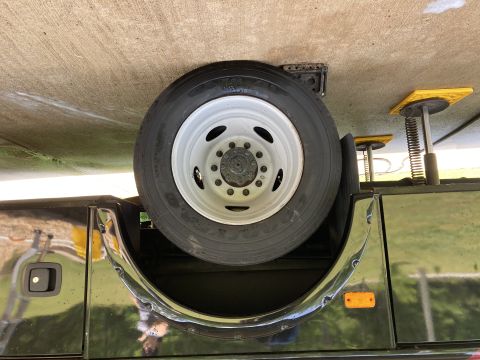 2015 Ford F-550 - Spare tire and jack stands visible beneath a vehicle.