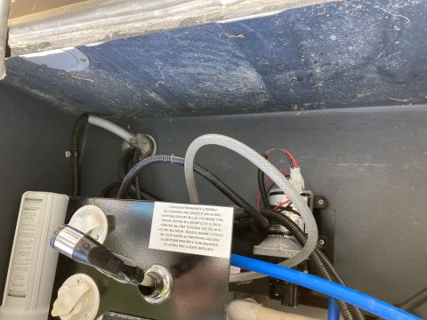 2015 Ford F-550 - Close-up of a water pump system with plumbing and a shower head attachment.