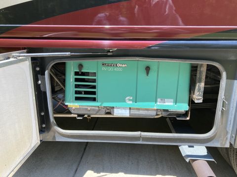 2015 Ford F-550 - A Cummins Onan RV generator is visible within a storage compartment of a recreational vehicle.