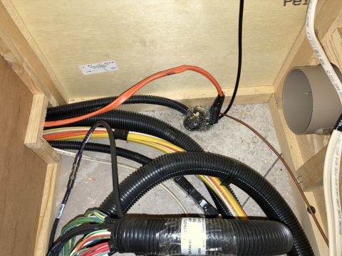 2015 Ford F-550 - A bundle of electrical wires, protected by corrugated tubing, is visible within a wooden compartment.