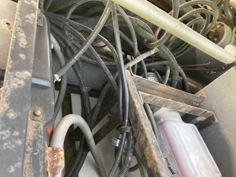 2015 Ford F-550 - A complex network of hoses and wiring is visible on the underbody of the vehicle, alongside a fluid reservoir.