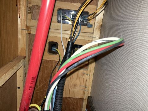 2015 Ford F-550 - A close-up view of electrical wiring and a junction box, with a red pipe visible.