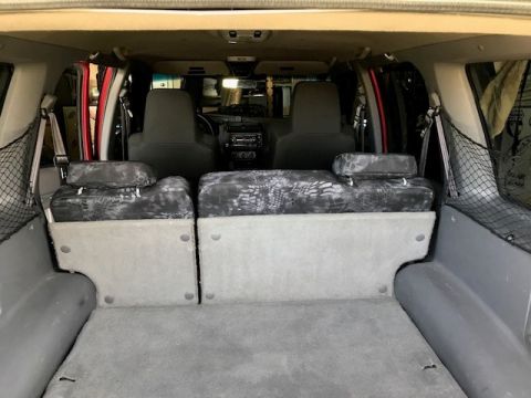 2000 Ford Explorer - The interior of an SUV shows the rear seats and cargo space, with custom seat covers.