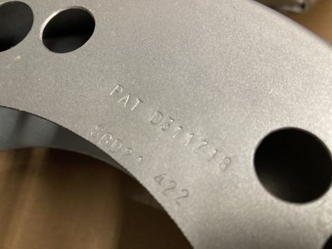2015 Ford F-550 - Close-up of a metal wheel balancer part showing stamped patent and part numbers.