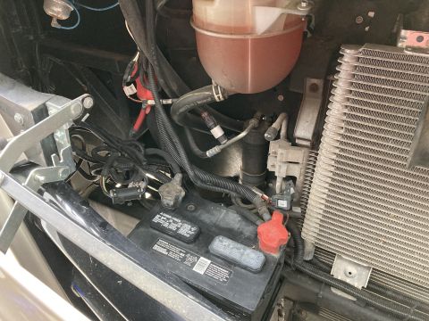 2015 Ford F-550 - Close-up view of a vehicle's battery and surrounding engine bay components.