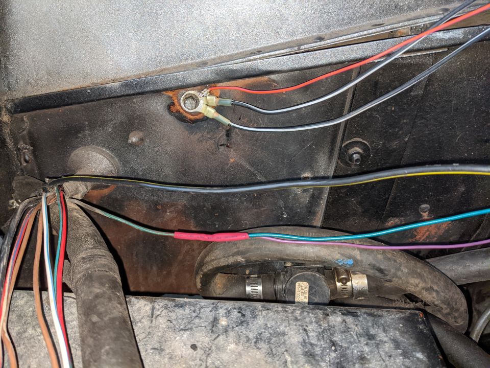 The 3 grounds from C115 ground to the old voltage regulator ground.  I wire wheeled the metal bare then covered it in silicone grease to get a good connection and hopefully prevent corrosion.  The big black/yellow wire used to go to the 302's alternator and now routes over the engine to the big yellow wire at the PDB.  The green/red wire from the voltage regulator provides RUN power to the purple/orange wire going to C115 and to the green wire I added which will go to a RUN/START relay shown in a later picture.