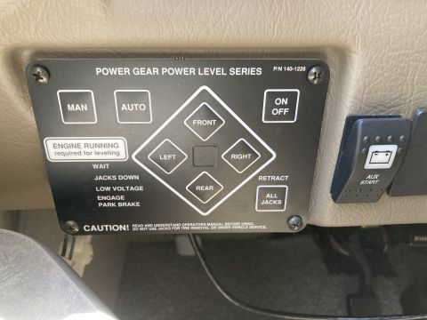 2015 Ford F-550 - A close-up view of a Power Gear Power Level Series control panel with various buttons and indicator lights. The panel is mounted on a beige…