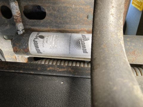 2015 Ford F-550 - A close-up view shows a Power Gear hydraulic jack mounted to a vehicle's frame. The jack is cylindrical and silver with black lettering, sh…