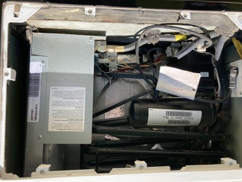 2015 Ford F-550 - RV refrigerator exterior service panel exposing cooling unit coils, wiring and warning labels.