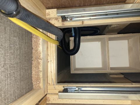 2015 Ford F-550 - A close-up view shows electrical wiring and conduit running through wooden framing and a small compartmentalized storage unit, possibly wit…