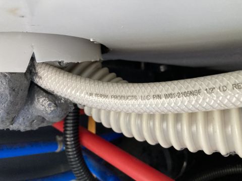2015 Ford F-550 - A white braided hose with text "VALTERRA PRODUCTS, LLC P/N W01-2105NSF 1/2" I.D. RE" is visible, running through a white plastic grommet. B…