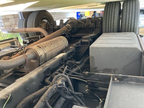 2015 Ford F-550 - A close-up, low-angle view of the undercarriage of a large truck, focusing on the dual rear tires, exhaust system, and suspension component…