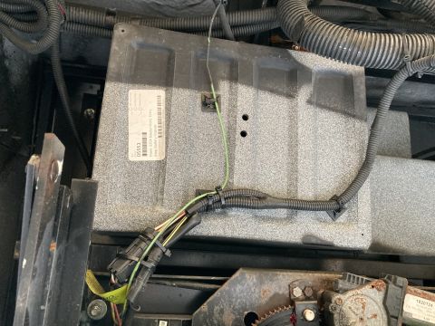 2015 Ford F-550 - A close-up view shows a gray electronic control module with a label that reads "05553 Fleet 0054 Master Weld Entry Step Battery Granite". W…