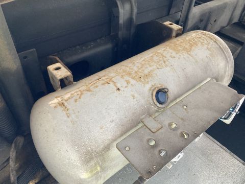 2015 Ford F-550 - A silver-colored air tank is mounted horizontally beneath a vehicle. The tank shows some rust spots and is secured by metal brackets.