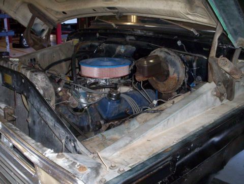 1978 Ford Bronco - The engine bay of a vehicle is shown with the hood open, revealing the engine components.