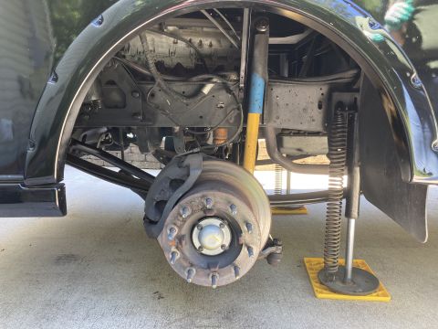 2015 Ford F-550 - The front driver's side wheel well of a black truck is shown with the brake rotor and caliper visible. The suspension components, including…