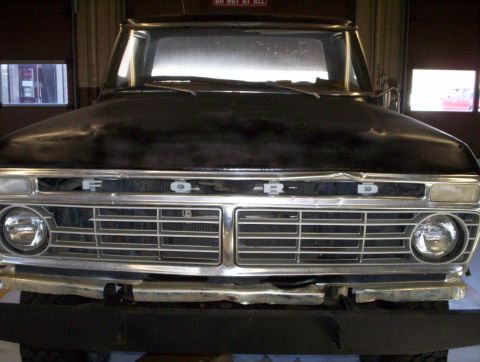 1978 Ford Bronco - Front view of a black 1973 Ford F-Series truck grille and headlights.