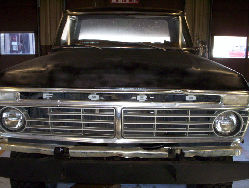 Front view of a black 1973 Ford F-Series truck grille and headlights