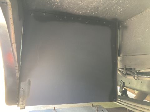 2015 Ford F-550 - A black metal plate is installed on the underside of a vehicle, likely as a mud flap or shield. The plate is secured with visible rivets al…