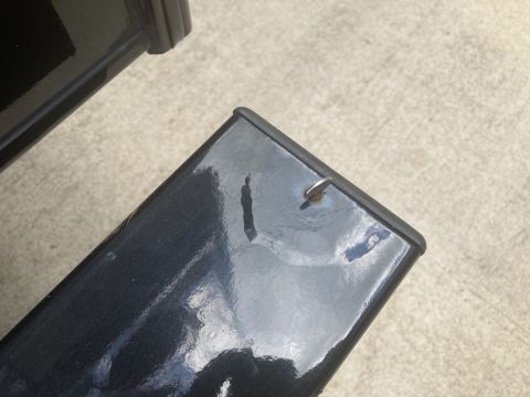2015 Ford F-550 - A close-up shows a shiny black surface with a small silver hook protruding from it. The surface appears to be part of a vehicle component r…