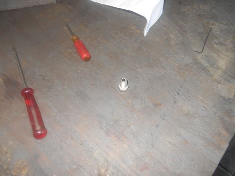 1992 Ford Bronco - Two screwdrivers, a hex wrench, and a bolt are laid out on a wooden surface.